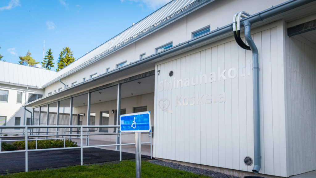 Kuva sisäänkkäynnistä. Seinässä teksti Sininauhakoti, Koskela.