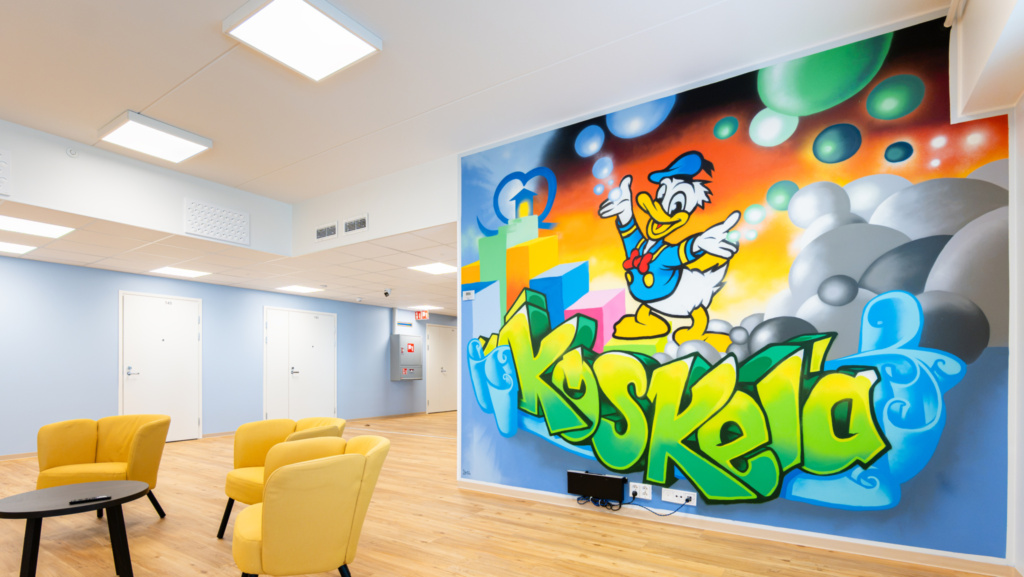 Sisäkuvassa graffitityylinen seinämaalaus.